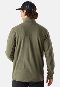 Oliivinvihreä fleece-takki, jossa on teksturoitu pinta, korkea kaulus ja pitkät hihat. Sisältää takana olevan yoke-yksityiskohdan paremman istuvuuden saavuttamiseksi.