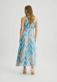 Sukienka maxi w niebiesko-różowy wzór w zygzak, na ramiączkach, z lekkiego materiału, z dopasowaną talią i rozkloszowanym dołem.