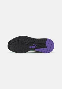 La suola delle sneaker Puma presenta una base in gomma nera con un motivo e accenti viola, insieme al logo. Il design include un battistrada testurizzato per una migliore aderenza.