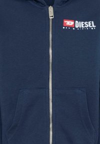 Felpa con cappuccio blu navy con cerniera, tasche frontali e logo Diesel bianco e rosso sulla parte superiore sinistra del petto.