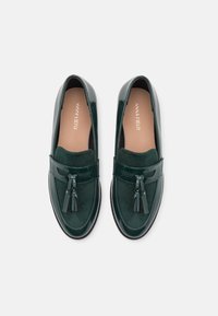Mocassins verts avec dessus en daim et accents en cuir verni. Présentent un détail à pampilles à l'avant et un design à bout lisse et arrondi.
