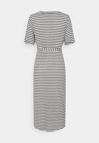 Tył białej sukienki do kolan z czarnymi poziomymi paskami, krótkimi rękawami oraz pasem w paski dopasowanym w talii.