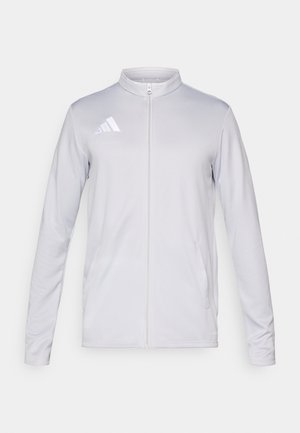 Lysegrå atletisk jakke med stående krave, fuld lynlås foran, to sidelommer og et reflekterende logo på venstre bryst.