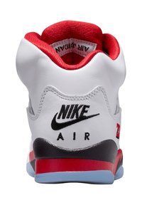 Baskets Nike Air Jordan avec une tige en cuir blanc, des accents rouges, un logo noir, un talon arrondi et une unité de amorti visible.