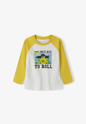 Witte lange mouwen T-shirt met gele raglanmouwen. Voorzien van een grafische print van een skateboarder en de tekst "DE ENIGE MANIER OM TE ROLLEN."