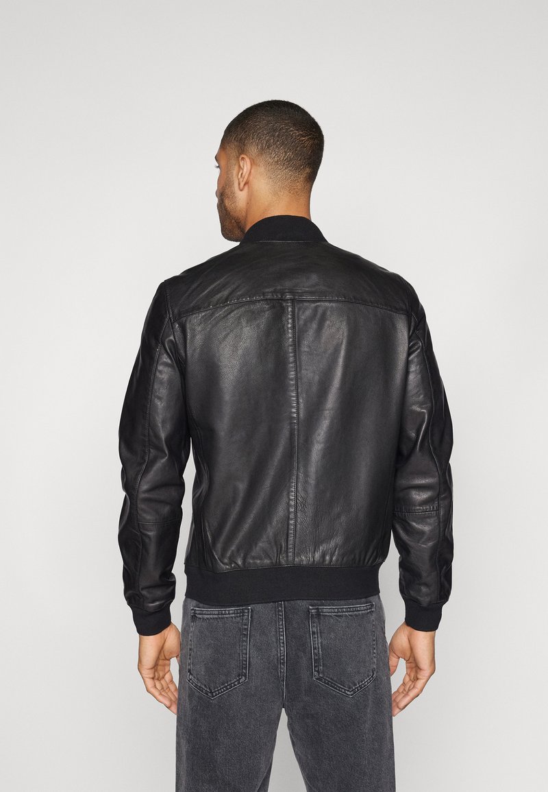Veste bomber en cuir noir avec des poignets et un ourlet côtelés, présentant une texture lisse et un design minimaliste. Vue de l'arrière.