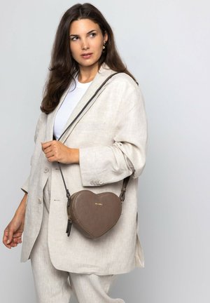 Brown heart-shaped handbag made of textured leather, featuring a detachable shoulder strap and gold logo detail on the front.