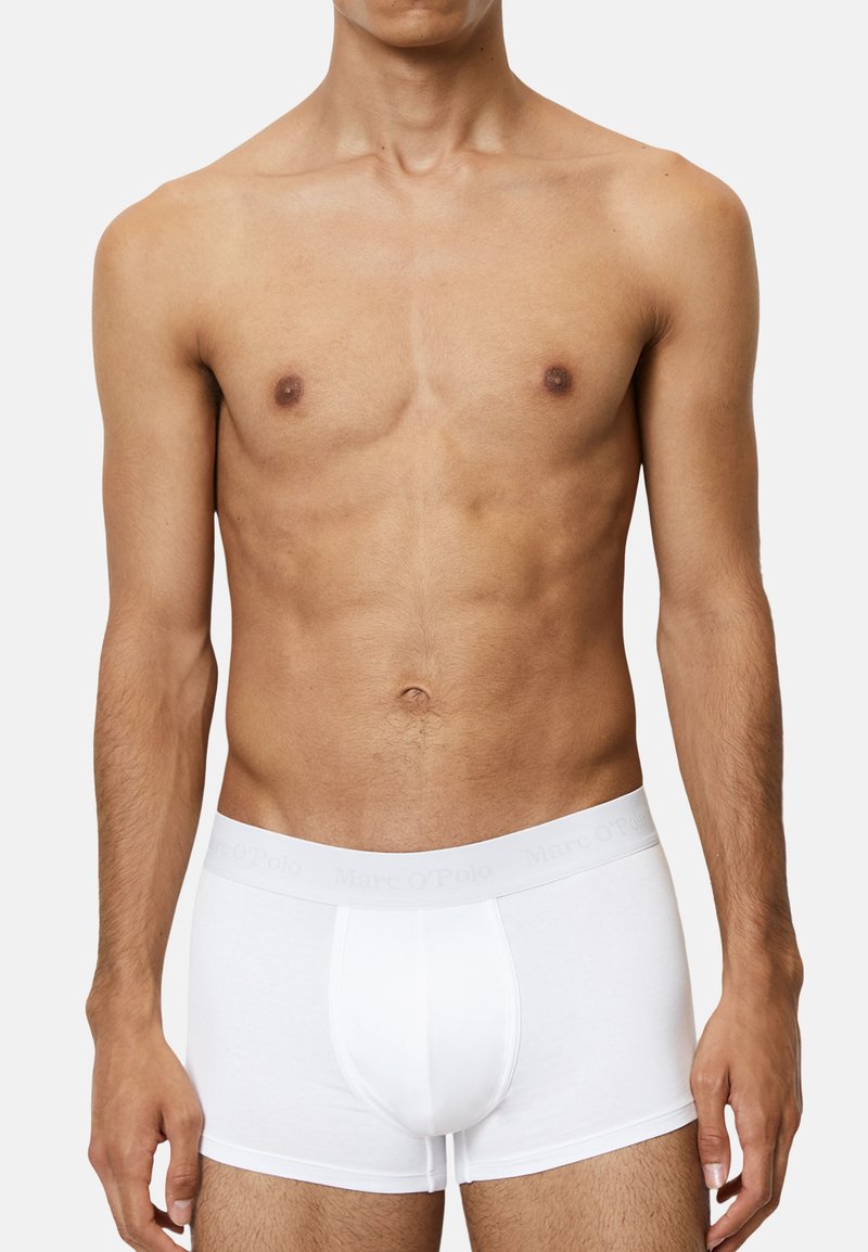 Witte boxershorts van een zachte stof, met een effen design en een grijze merkband aan de taille. De pasvorm is strak en de lengte is tot halverwege de dij.