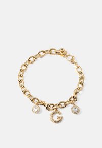 Armbandet i guldton har tre berlocker: ett glittrande bokstav "G" och två juvelprydda cirkulära accenter, vilket ger en elegant touch.