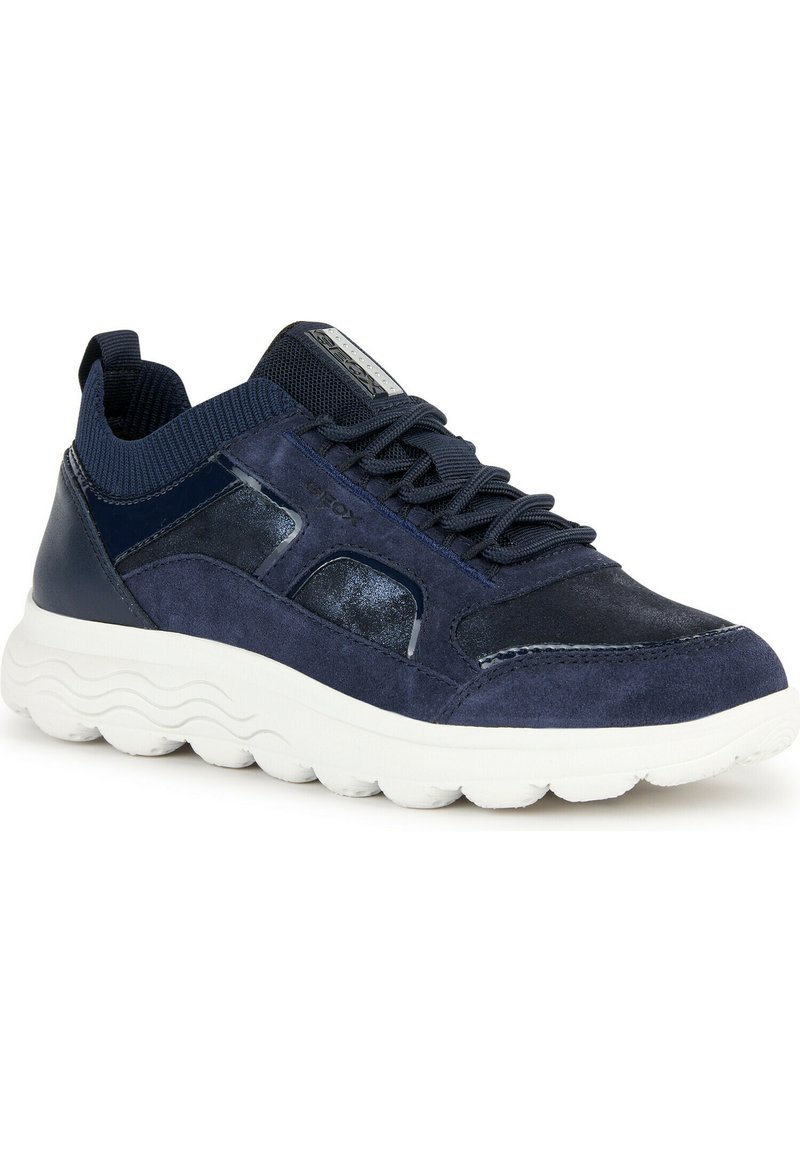 Zapatillas navy con detalles de ante y cuero brillante, collar de malla texturizada, suela blanca acolchada y diseño de cordones. Detalle del logo metálico en la lengüeta.