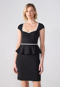 Svart peplumklänning med fyrkantig halsringning, korta ärmar och vita detaljer. Slät textil med en figursydd kjol. Inga synliga mönster.