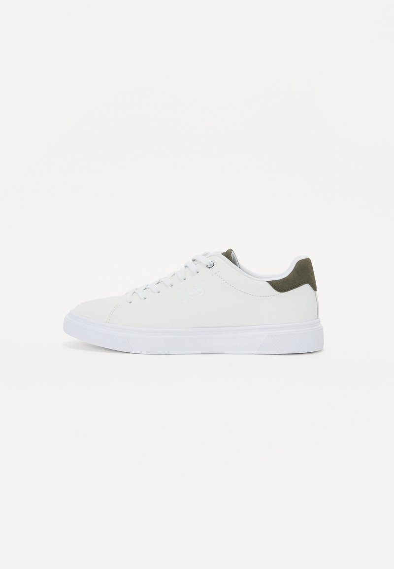 Hvit sneaker med en glatt suedeluc, kontrasterende olivengrønn hælflik, runde hvite snører og gummisåle. Minimalistisk design.