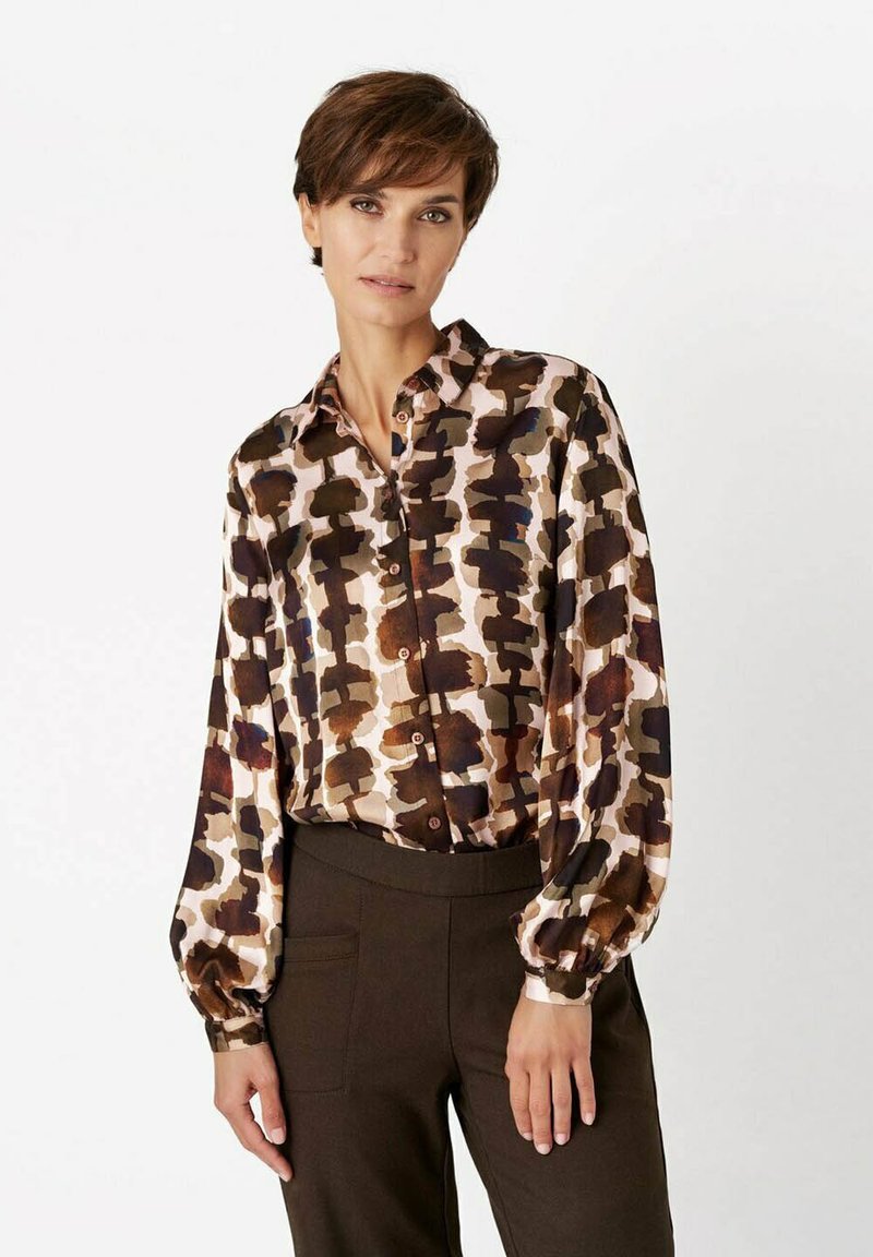 Silk blouse featuring a brown, cream, and navy abstract pattern, long sleeves with gathered cuffs, and a classic collar with buttons.