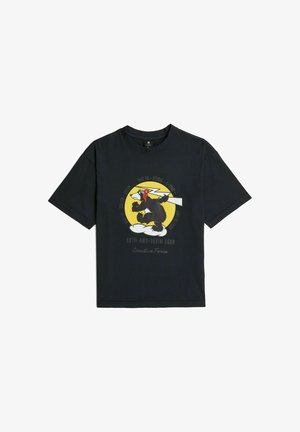 T-shirt noir à manches courtes avec un chien cartoon portant un masque rouge et des gants, debout sur des nuages à l'intérieur d'un cercle jaune avec du texte autour.