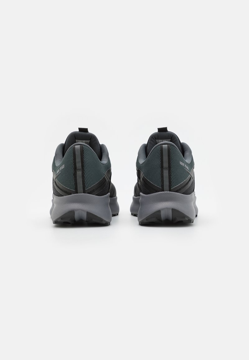 Zwarte en grijze sportschoenen met een bovenkant van mesh, een gevoerde kraag en gestructureerde zolen, voorzien van een trekhaak en reflecterende accenten.
