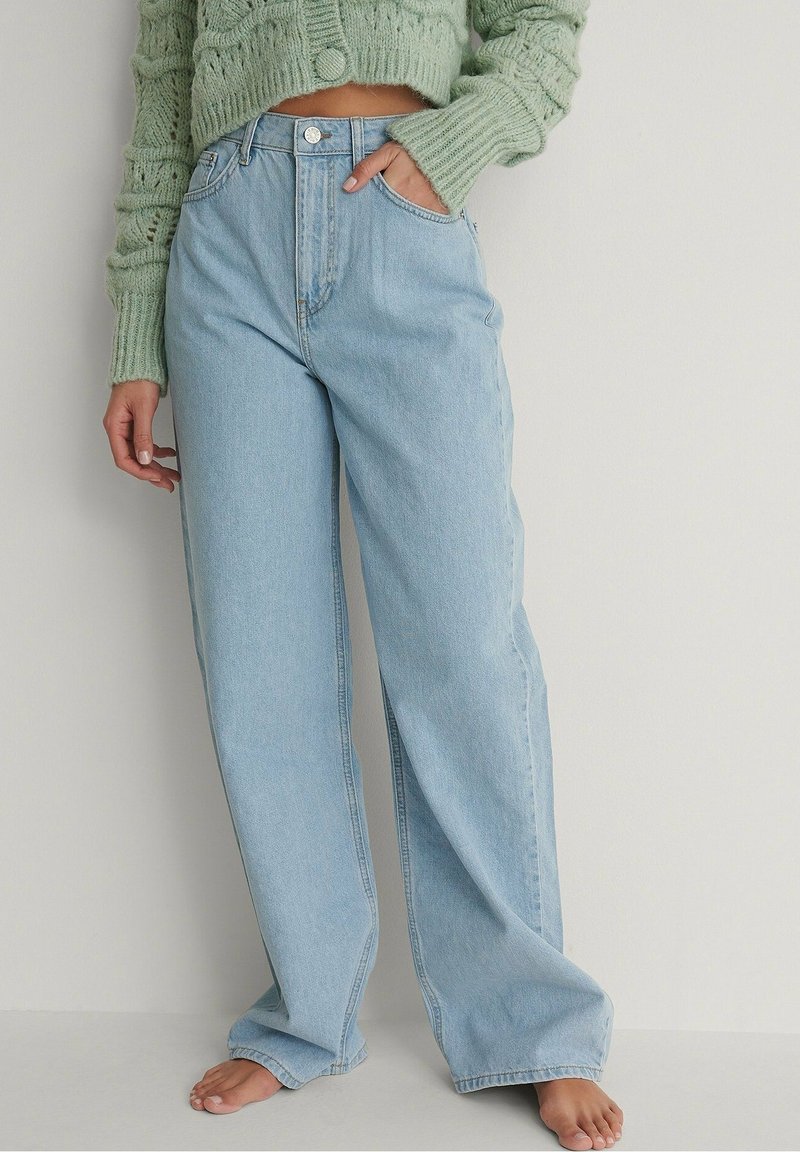 Ljusblå vida jeans med hög midja, med knappstängning, frampockets och en något slitna nederkant.