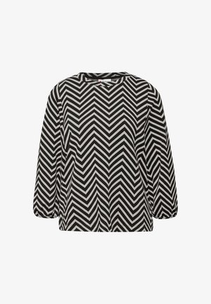 Blusa de patrón de chevron en blanco y negro con mangas largas, cuello redondo y corte holgado. Tejido texturizado con una apariencia suave.