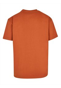 Oranje T-shirt met korte mouwen, gemaakt van katoen. Heeft een ronde halslijn en een rechte pasvorm. Heeft een zachte textuur met een eenvoudig ontwerp. Geen graphics of patronen.