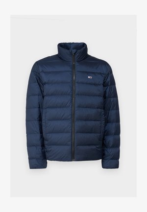 Tumedat sinine puhvjakas kõrge kraega, lukuga ja horisontaalse tikandiga. Valmistatud kergest sünteetilisest materjalist.