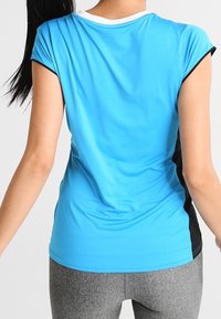 Kurzes Sportoberteil in Hellblau mit einem schwarzen Seitenstreifen, aus einem glatten, atmungsaktiven Stoff, mit Rundhalsausschnitt und leichtem Stretch.