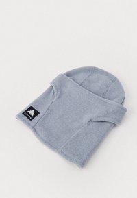 Szara czapka beanie z polaru o zwiniętym wzorze i czarną łatką logo, charakteryzująca się gładką teksturą i zaokrąglonym kształtem, odpowiednia na chłodniejsze dni.