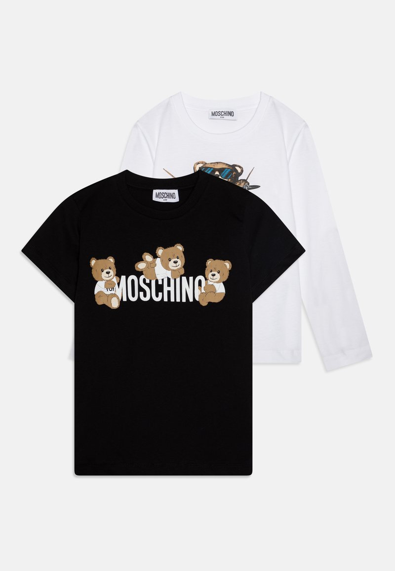 Camiseta negra de manga corta con gráficos de osos y el texto "Moschino", superpuesta sobre una camiseta blanca de manga larga con diseño de oso y gafas de sol azules.