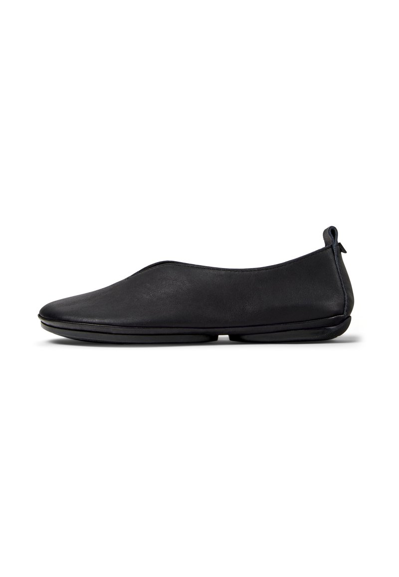 Scarpa nera in pelle slip-on con una finitura liscia, punta arrotondata e un tacco sottile. Presenta un design minimalista e un comodo pull tab sul retro.