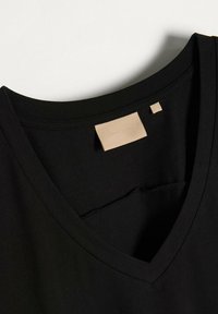 Czarny t-shirt z dekoltem w serek, wykonany z miękkiego materiału, charakteryzujący się gładką fakturą i małą beżową metką marki wszytą wewnątrz dekoltu.