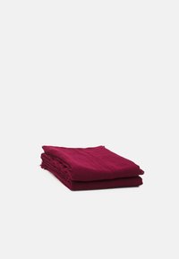 Tessuto di cotone bordeaux, piegato in tre strati, con una superficie leggermente tessurizzata e bordi sfrangiati, su uno sfondo bianco semplice.