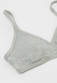 Šedá, měkká bavlněná trojúhelníková braletka s nastavitelnými ramínky a vlnkovým zdobením podél výstřihu. Bezešvý design a minimalistický tvar.