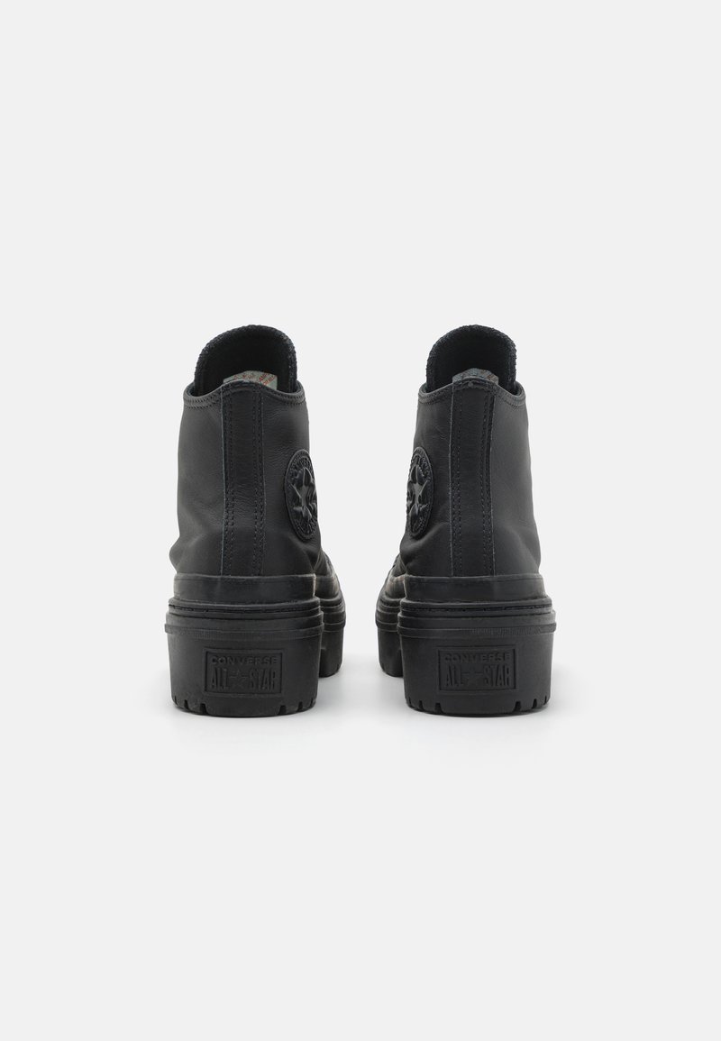 Zwarte leren enkelboots met een ronde neus, gestructureerde zijkanten en een rubberen zool; voorzien van een logo-embleem op de achterkant en de tong.