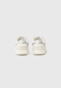 Hvide lædersneakers med en struktureret overflade, der har en sølvfarvet hælaccent og polstret sål. Minimalistisk design uden mønstre.