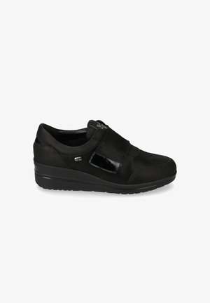Scarpa nera bassa senza tacco, realizzata in tessuto strutturato, con fascia in velcro e suola liscia, progettata per comfort e facilità di utilizzo.