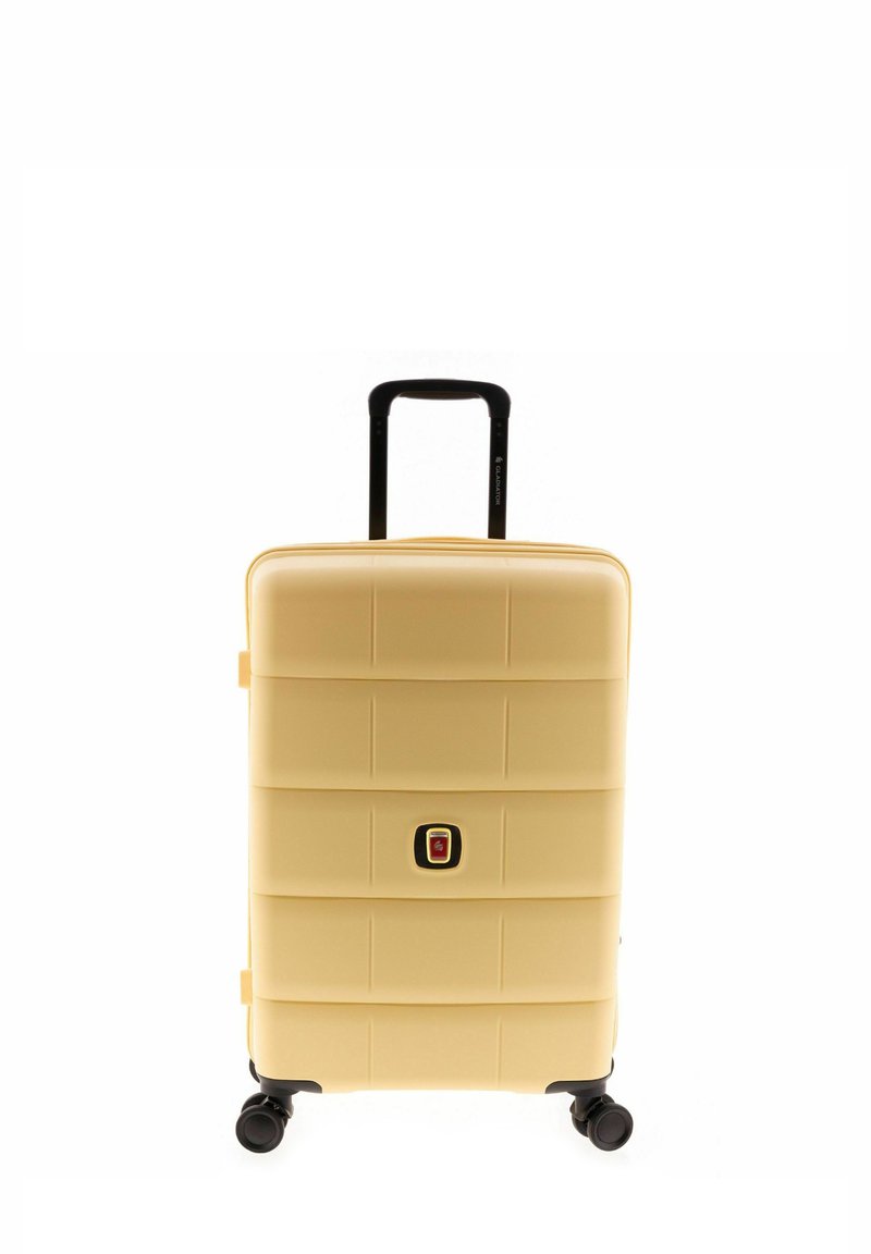 Maleta rígida de color amarillo pálido con diseño segmentado, un mango empotrado y cuatro ruedas negras para mayor movilidad. Incluye un mecanismo de cierre.