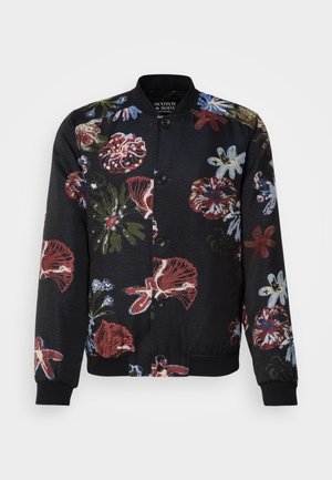 Μαύρο μπόμερ μπουφάν με λουλουδάτο σχέδιο, διαθέτοντας έντονα κόκκινα, μπλε και πράσινα λουλούδια, στρογγυλή κολάρα και ριμπ μανίκια και στρίφωμα.