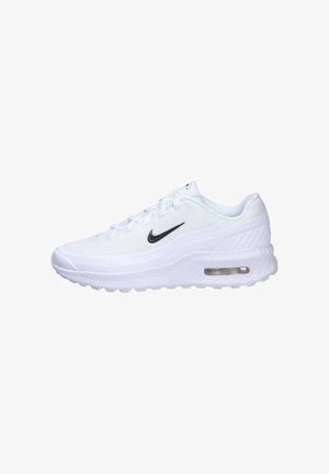 White Nike athletic shoes with mesh upper, black swoosh logo, and visible air cushioning in the heel. Thick rubber outsole and lace-up design.