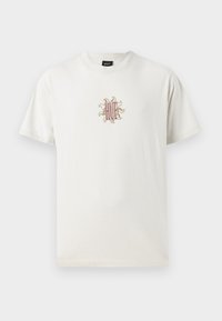 Kremfarget bomullst-skjorte med rund hals. Har et brodert soldesign og "HUF"-logo i sentrum. Korte ermer, avslappet passform.