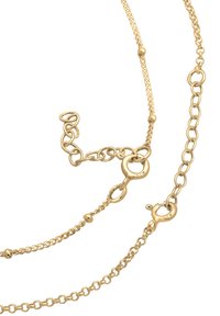 Collana color oro con più anelli di catena, dotata di chiusura a granchio e elementi decorativi, con anelli di diverse dimensioni e forme.