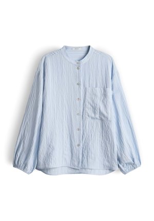 Blouse bleu clair à manches longues avec col mandarin, boutons sur le devant, une poche poitrine et un tissu texturé froissé.