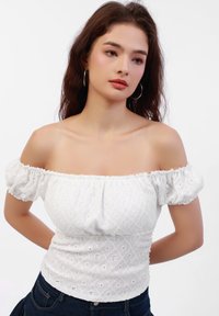 Weiße schulterfreie Bluse mit Puffärmeln, strukturiertem Baumwollstoff mit bestickten Mustern, tailliertem Oberteil und elastischem Bund.