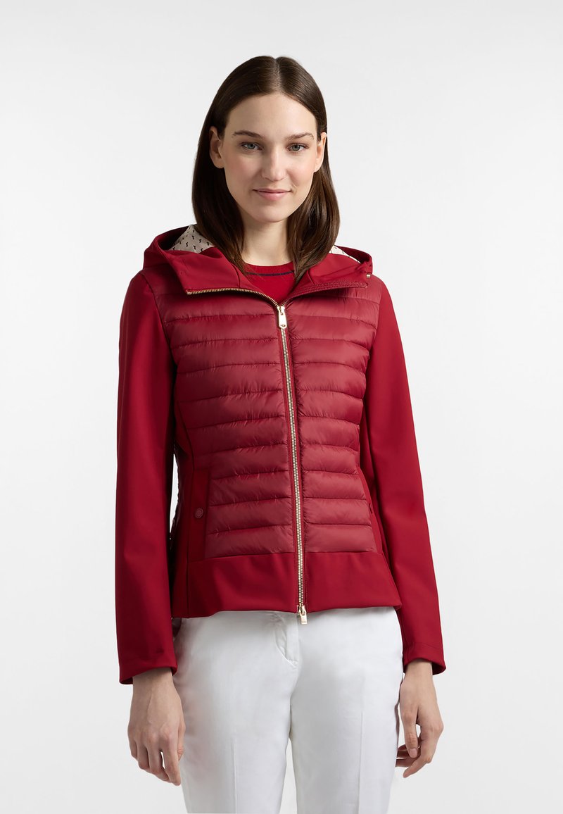 Rode jas met een opgeblazen textuur aan de bovenkant, een glad gedeelte aan de onderkant, een ritssluiting aan de voorkant, een capuchon en een gebreide voering.