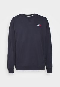 Navy sweatshirt made of cotton blend, featuring a crew neck, long sleeves, and a small logo patch with horizontal color stripes on the chest.
