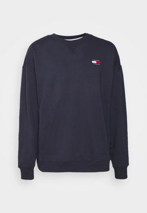 Navy sweatshirt made of cotton blend, featuring a crew neck, long sleeves, and a small logo patch with horizontal color stripes on the chest.