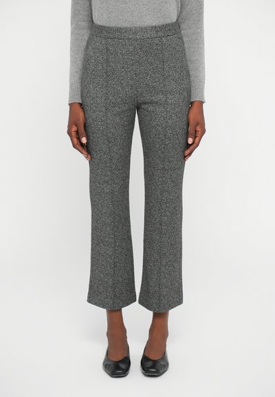 Grau strukturierte Hose mit einer taillierten Taille und weitem Saum, aus einem weichen Stoff gefertigt. Kombiniert mit schwarzen geschlossenen Schuhen.