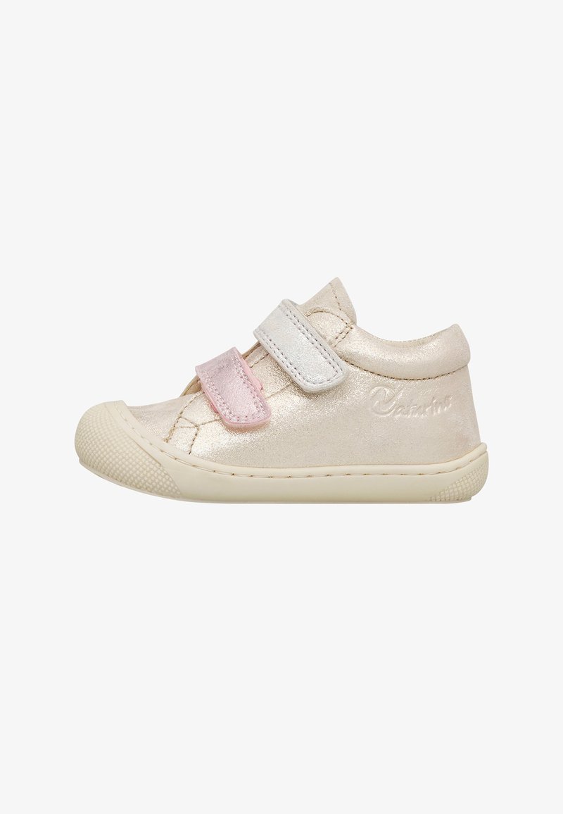 Beige kindersneaker met twee klittenbandsluitingen, één roze en één witte, en een gerubberde zool en neuskap met structuur.