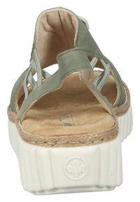 Sandale en suède vert avec un design ouvert, des accents tressés et une semelle intérieure texturée beige ; présente une semelle de plateforme blanche et nervurée.