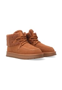 Braune Wildleder-Stiefeletten verfügen über einen flauschigen Schaffellbund, eine abgerundete Spitze und strukturierte Schnürsenkel, die auf einer Gummisohle mit niedrigem Profil sitzen.