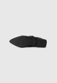 Scarpa nera con tacco alto, caratterizzata da una punta affilata, una tomaia in materiale sintetico liscio, una cinghia alla caviglia regolabile e una suola texturizzata con branding.