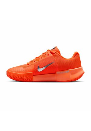 Helle orange Nike-Schuhe mit strukturiertem Mesh-Obermaterial, silbernem Swoosh-Logo und einer Gummisohle mit Zickzack-Muster.