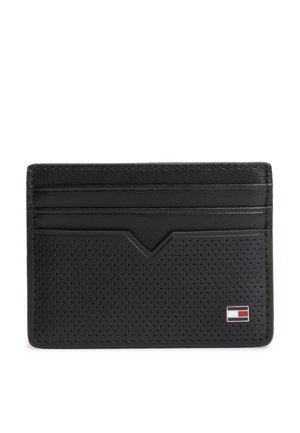 Tarjetero de cuero negro con parte frontal perforada, tres ranuras para tarjetas y un pequeño logo rectangular en rojo, blanco y azul en la parte inferior derecha.